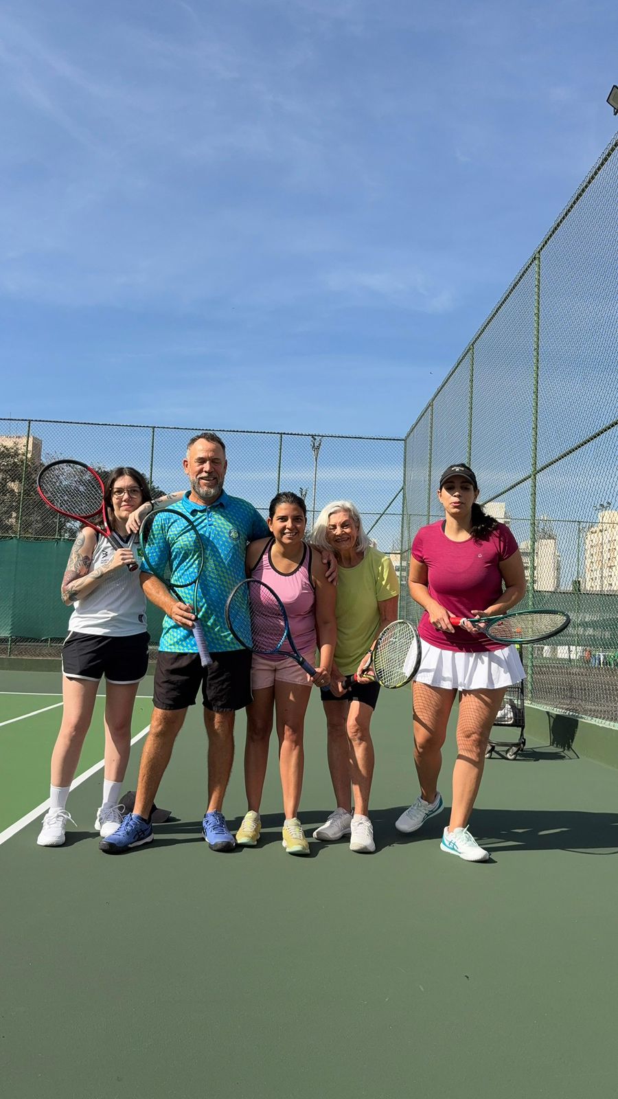 Grupo de alunos e professor na quadra do Método Vip Tennis